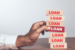 Person stacking blocks labeled "LOAN".