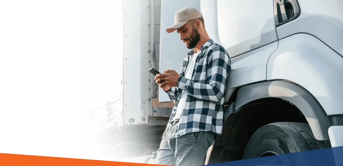 Truck driver using a smartphone, representing cash flow solutions for the trucking industry.
